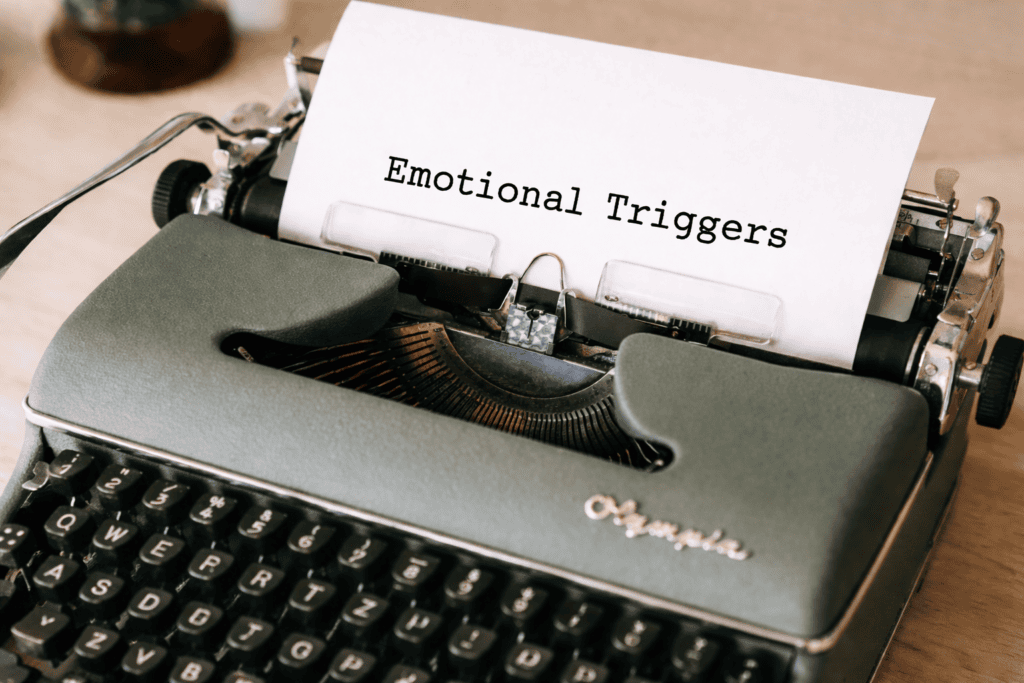 a typewriter, with the words "emotional triggers" on it, which matches the topic of the article